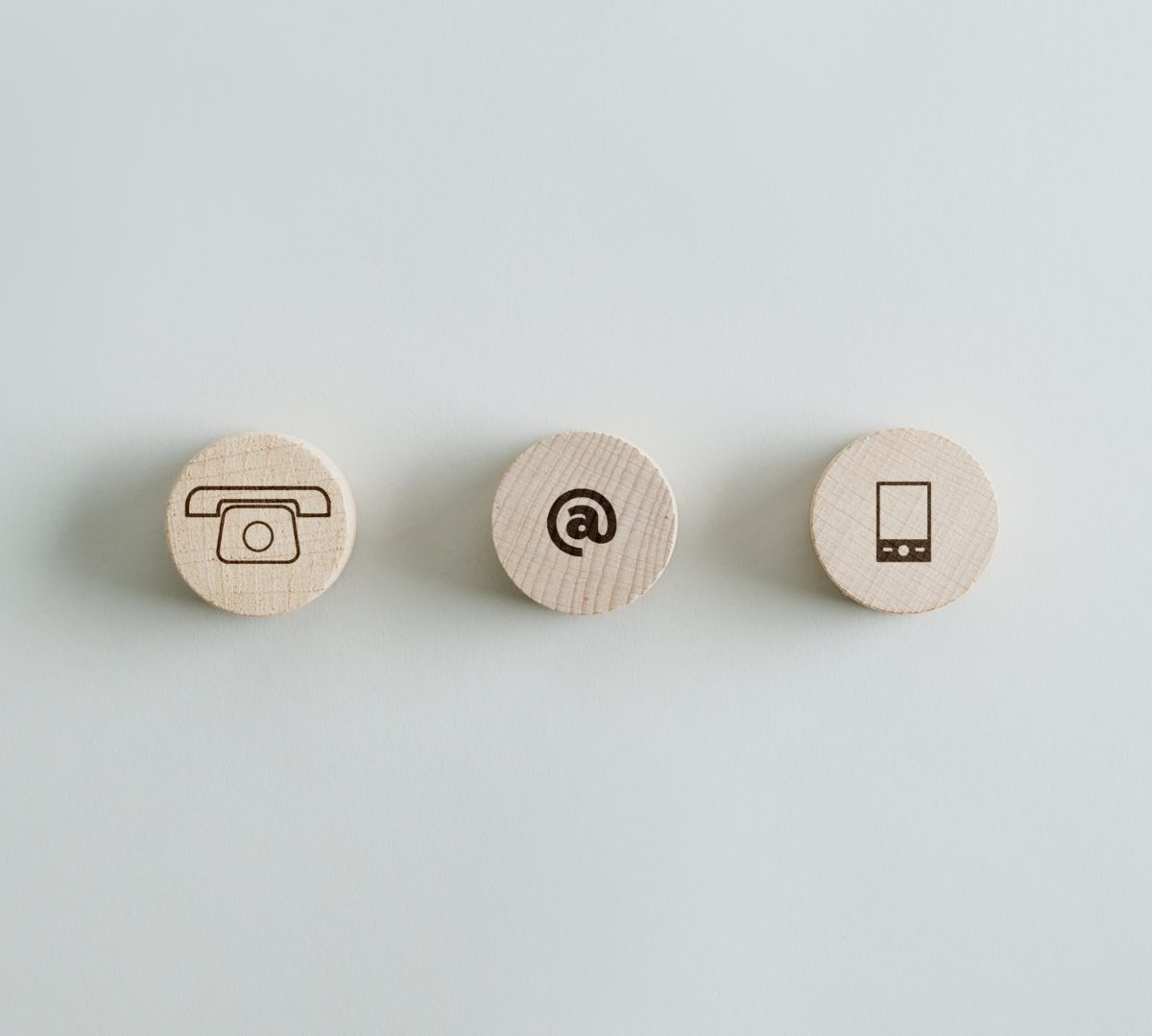 Three wooden circles with contact and communication icons